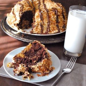 chocolate and caramel cake slice with glass of milk and fork