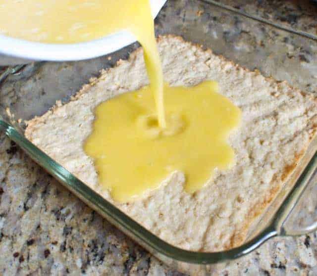 Lemon filling being poured on top of shortcake crust 