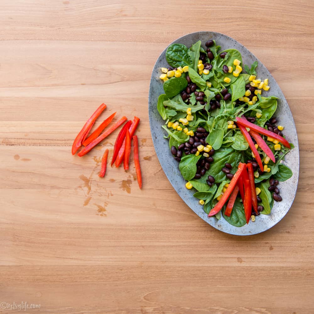 assembly of a salad on a metal oval shaped plate 