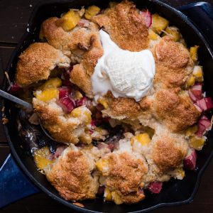 round dish of cobbler topped with melting vanilla ice cream