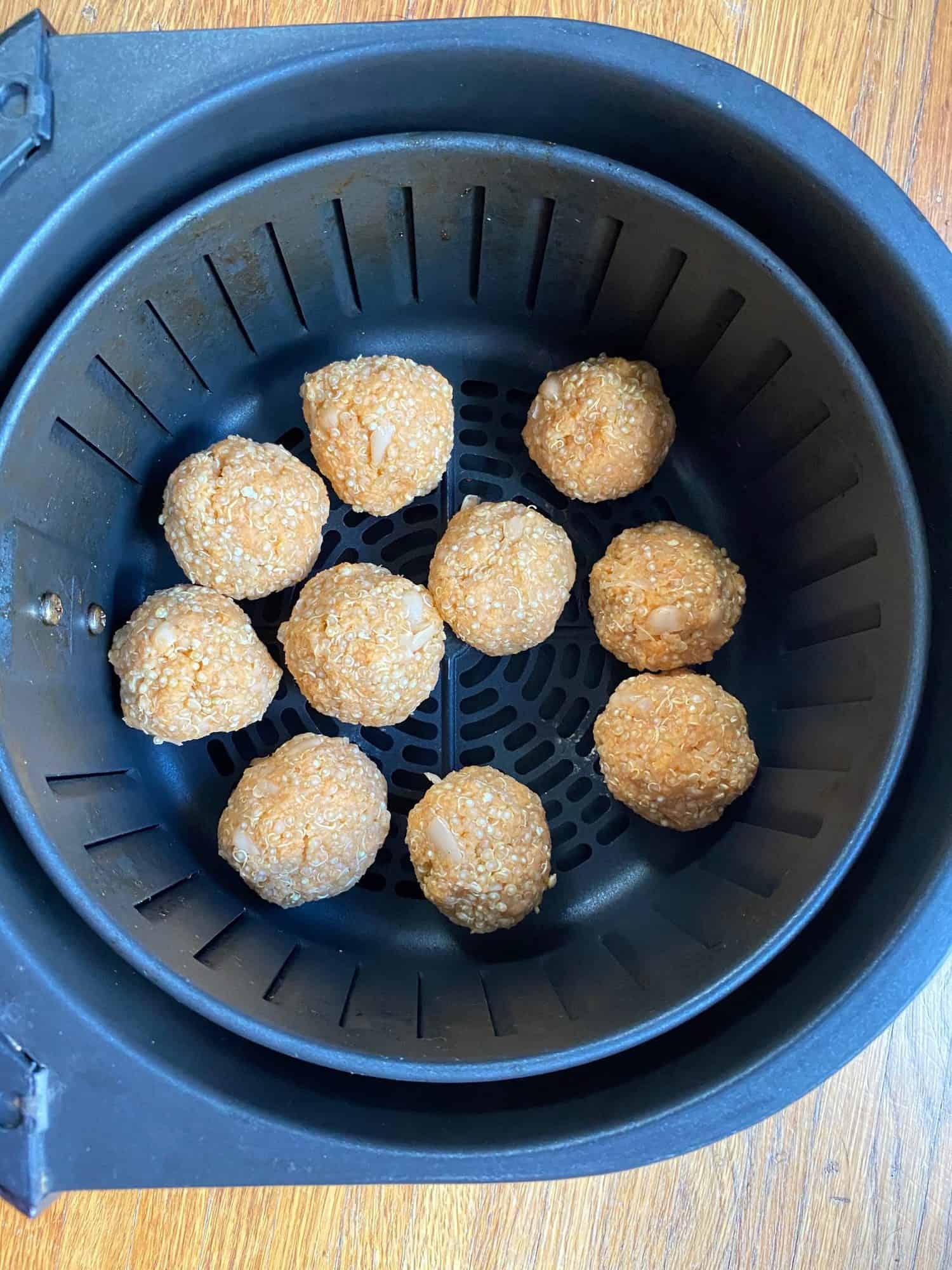 Air fryer basket full of quinoa bites 