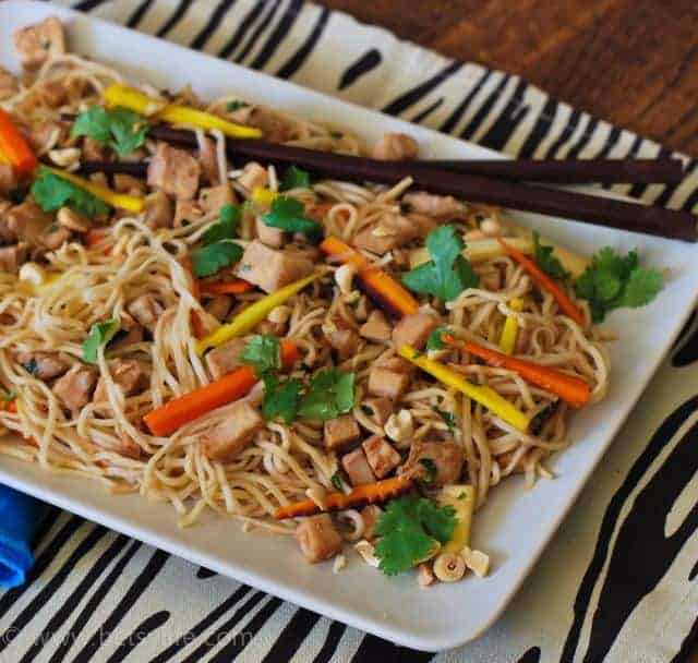 noodles with colorful vegetables on white plate with chopsticks