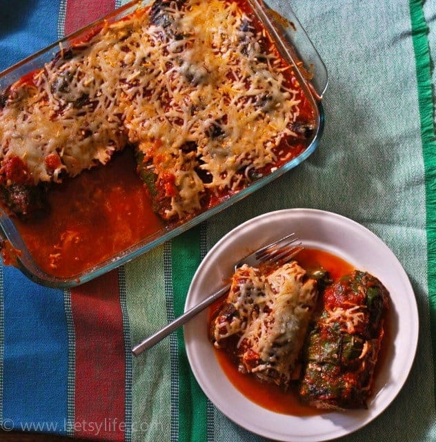 casserole dish of low carb cannelloni next to a plate with a serving on it. Striped linen background 