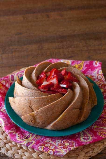 bundt cake topped with strawberries on pink napkin