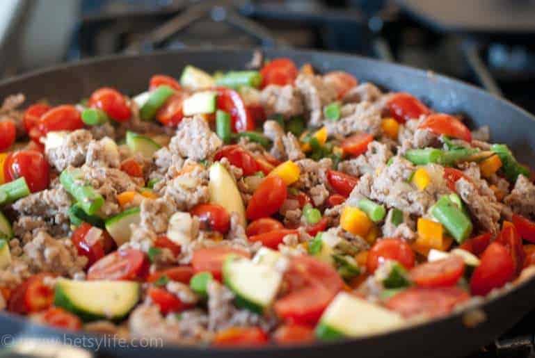 Ground meat and veggies cooking in a skillet 