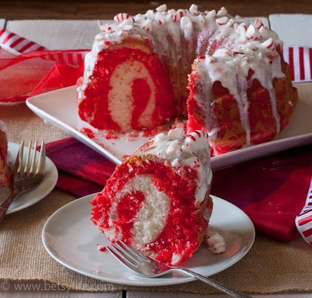 Peppermint Candy Bundt Cake with a slice removed on a plate. Inside of cake exposed to show a white and red swirl on the inside