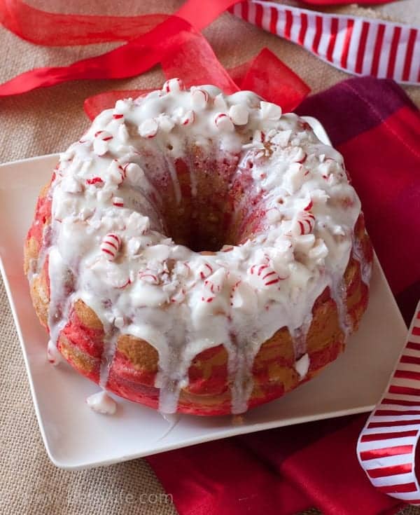 Peppermint Candy Bundt Cake on a white square plate with white and red ribbons around it