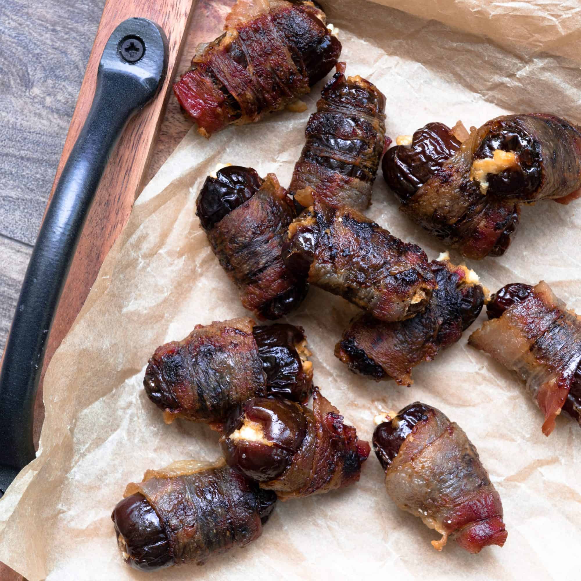 Bacon wrapped dates on a brown parchment paper