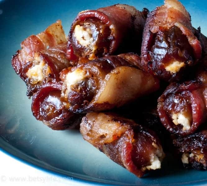 bacon wrapped dates on blue plate