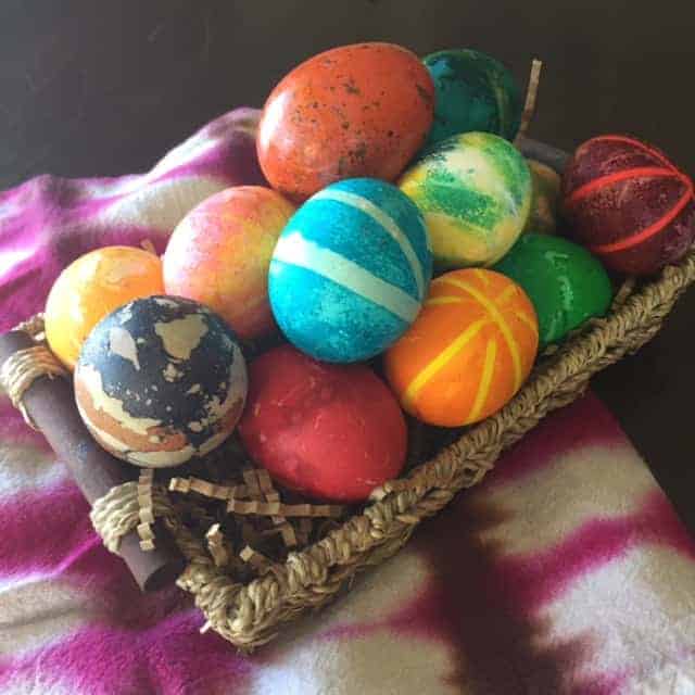 Basket of colorful dyed Easter eggs in a rainbow of colors