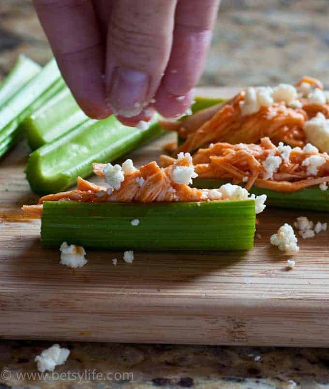celery sticks filled with buffalo chicken and sprinkled with cheese