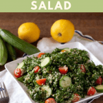 Kale Quinoa Tabbouleh Salad on a square white plate with cucumbers and lemons in the background