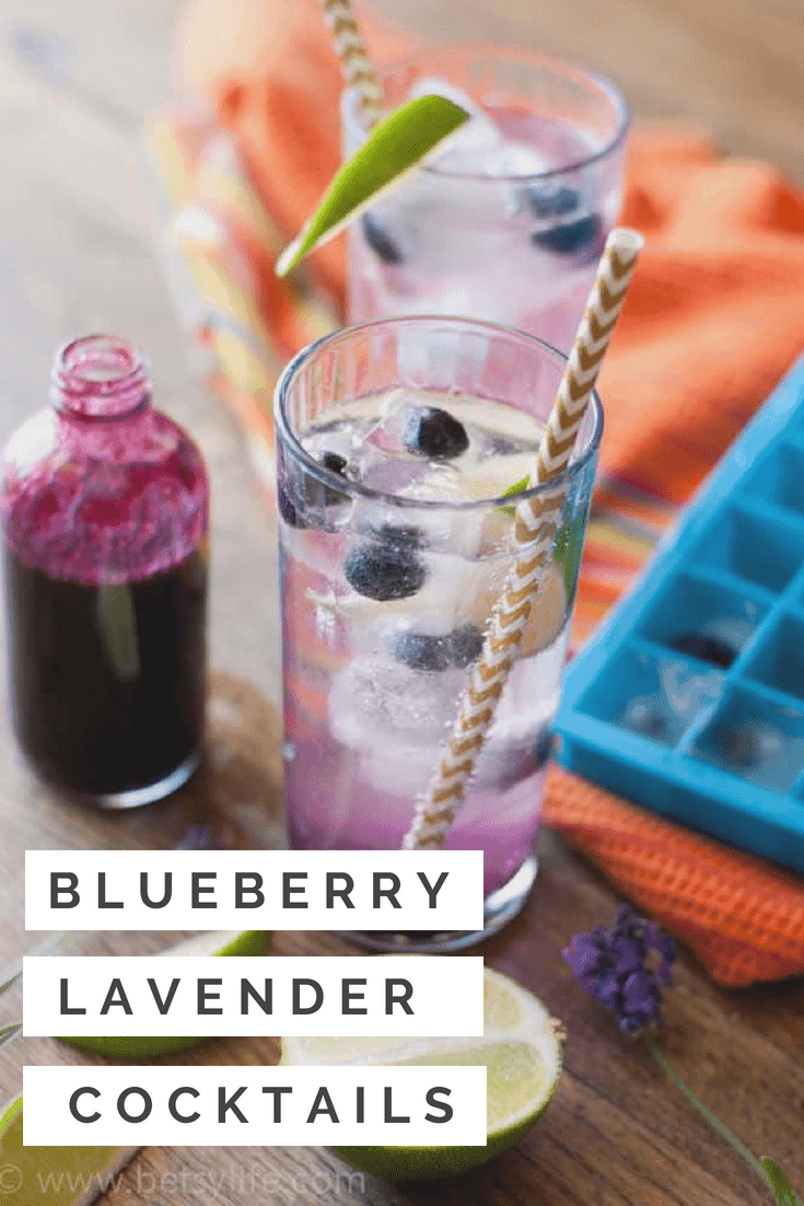 Blueberry Lavender Cocktail on an orange linen with a bottle of blueberry syrup and a blue ice cube tray 