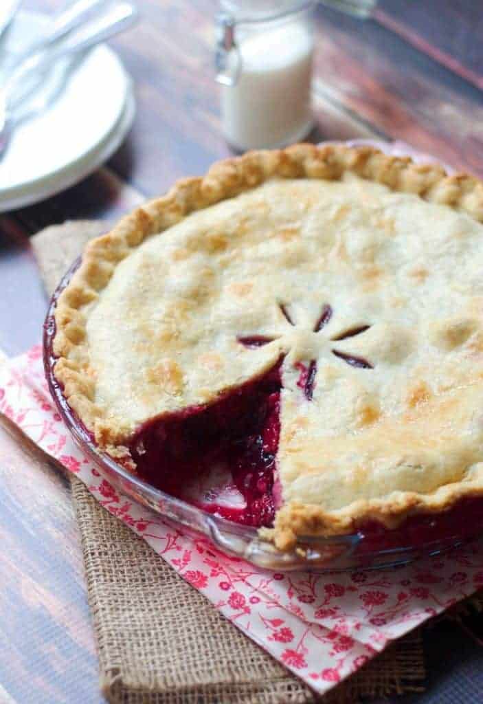 Mixed berry pie on a pink floral print napkin. One slice removed. 