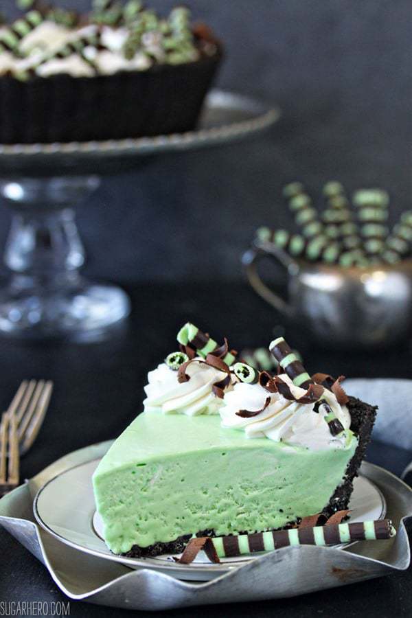 Green grasshopper pie with whipped cream and chocolate and mint straw decorations. 