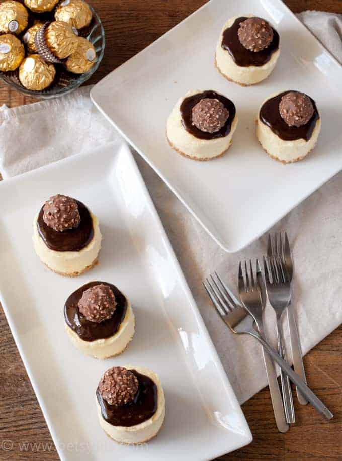 Mini Cheesecakes on white plates with forks and bowl of truffles