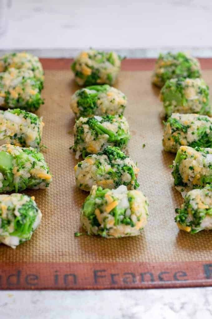3 rows of cheddar, ranch, broccoli tots uncooked on a silpat mat