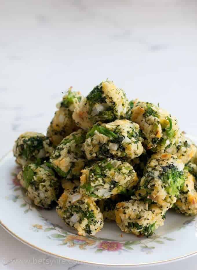 A pile of cheddar, ranch, broccoli tots on a white floral print plate