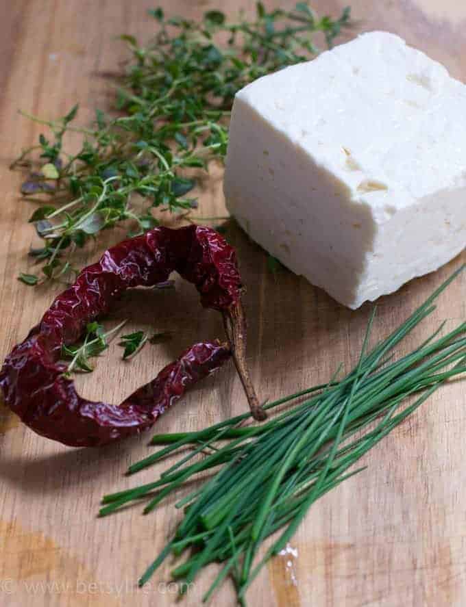 Ingredients for marinated feta on a cutting board 