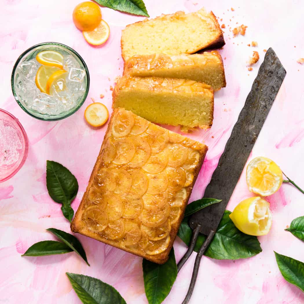 Sliced lemon loaf next to a glass of 7up and a knife 