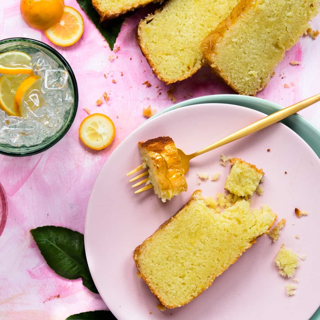 Detail of a slice of lemon 7up cake on a pink plate with a gold fork 