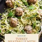 Turkey Meatballs with Zucchini Spaghetti on a brown oval platter with a fork and a spoon