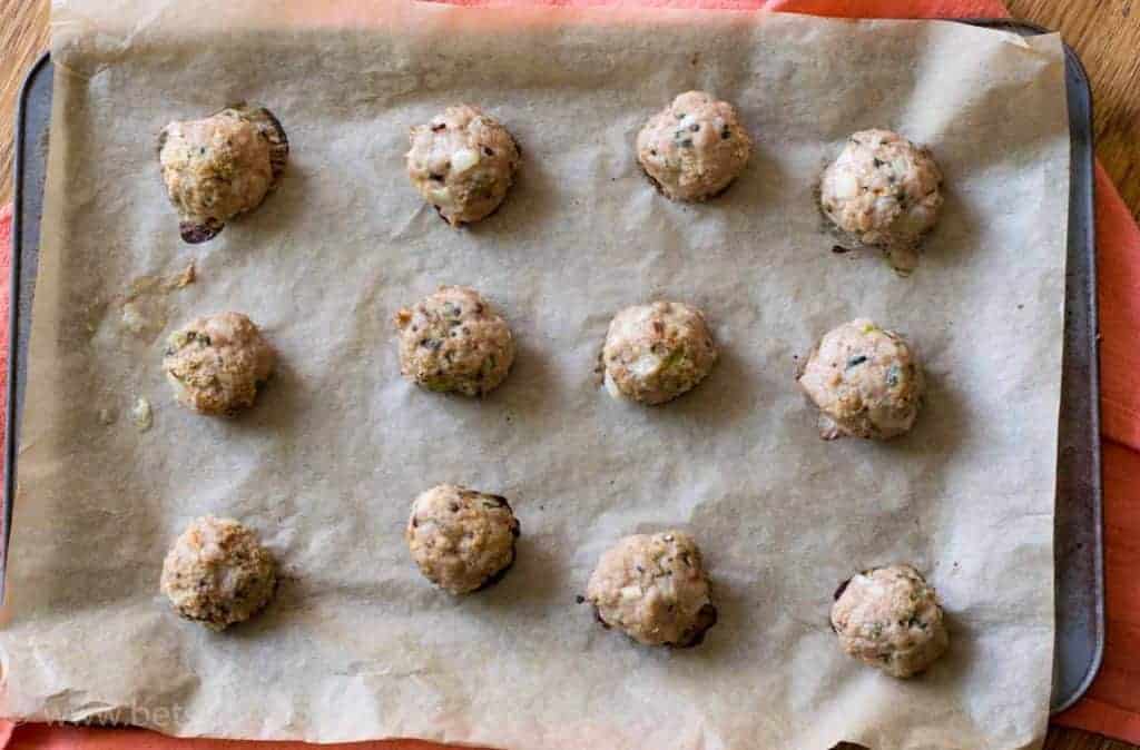 Turkey meatballs on a baking sheet lined with parchment paper. Fully cooked