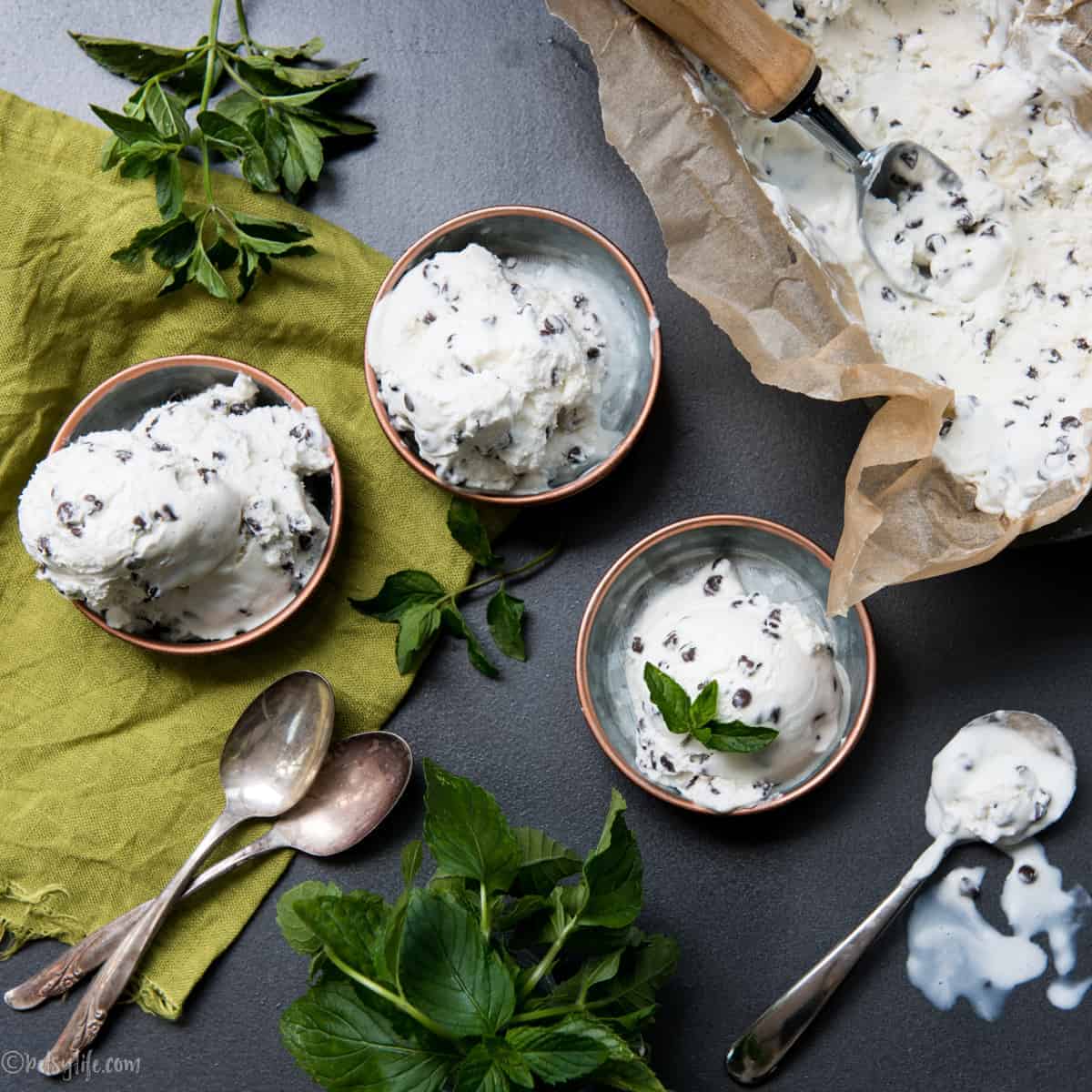Fresh mint chip ice cream in 3 small bowls on a dark background