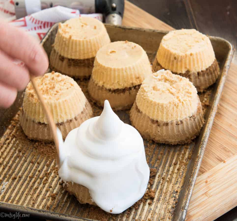 individual baked alaska with meringue topping being smoothed out with a wooden knife 