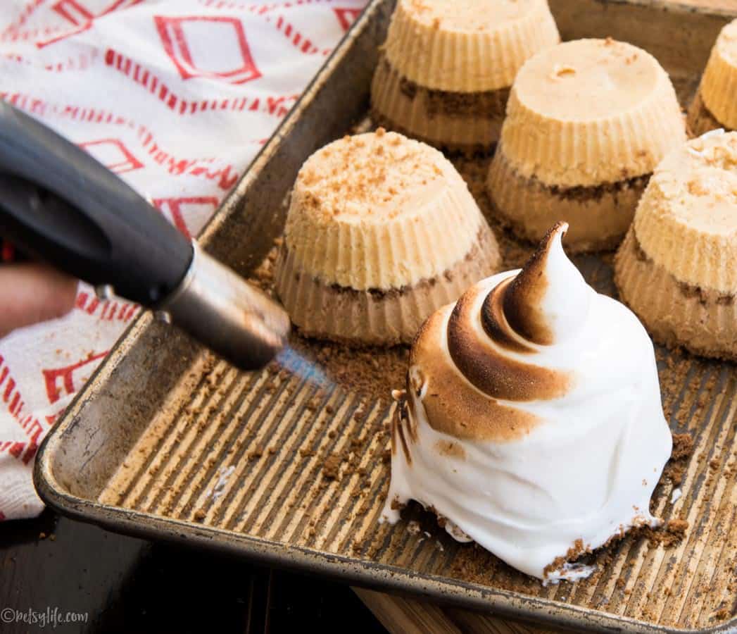 individual baked alaska being torched with a small kitchen blow torch 