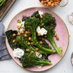 Roasted Broccolini with Crispy Kale, Chickpeas and Burrata on a pink plate