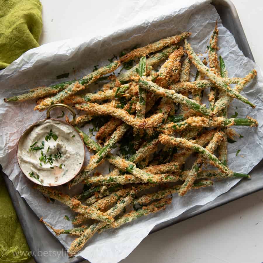 baking sheet of crispy green bean fries with dipping sauce 