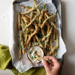 sheet pan of air fryer crispy green bean fries with a dipping sauce