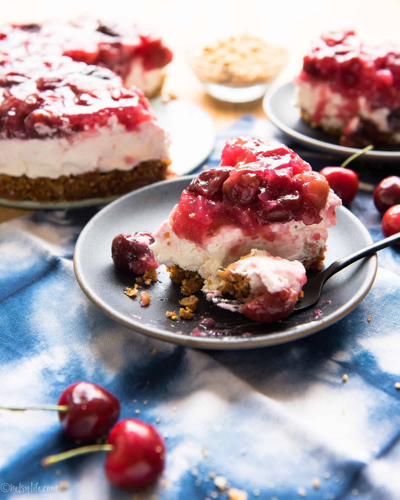 slice of cherry cream pie with bite out of it on a gray plate