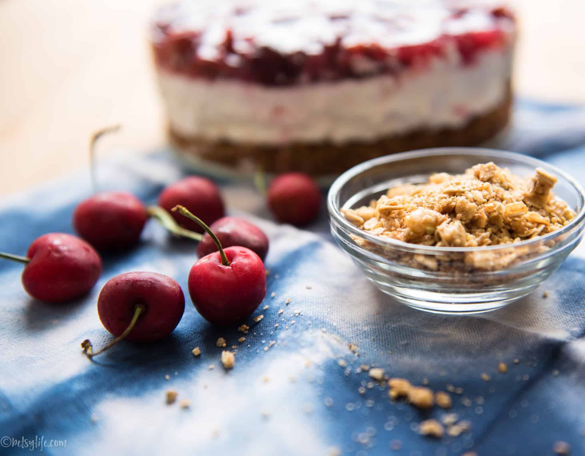 bowl of granola and fresh cherries in front of cream pie 