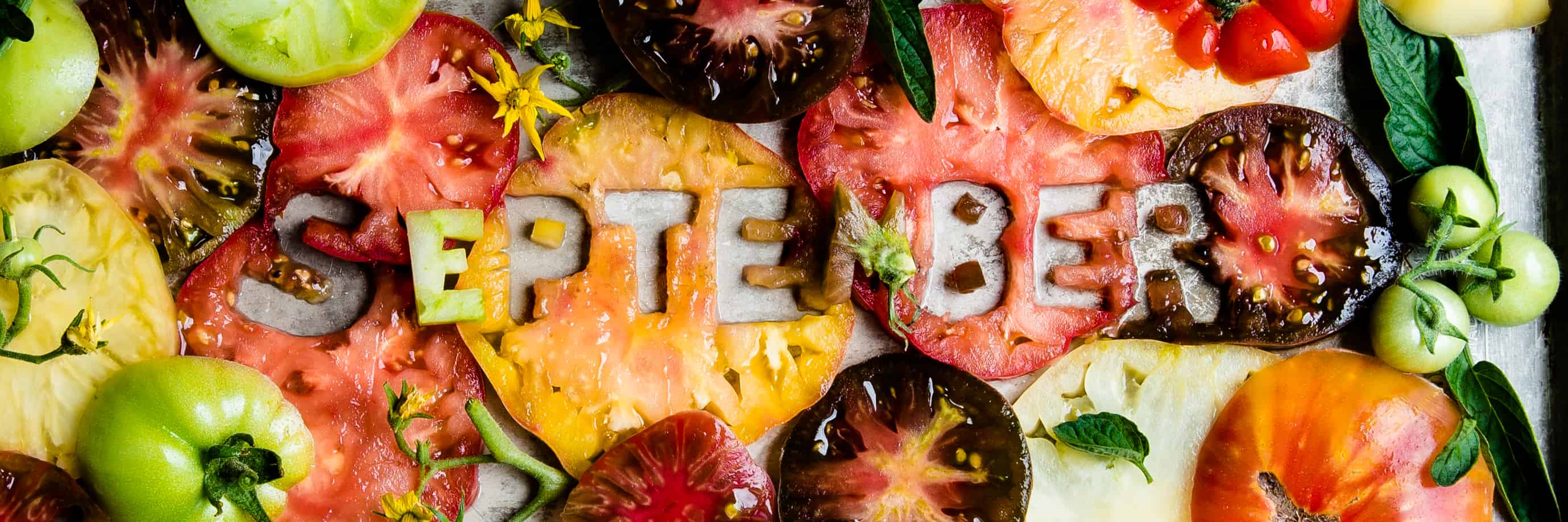 creative food styling banner image of tomatoes that spell out September 