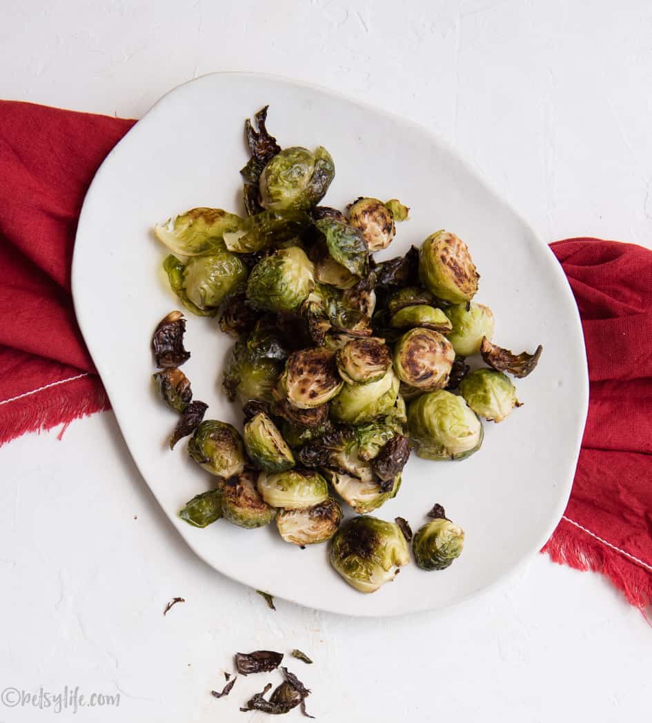 roasted brussels sprouts on an oval white dish with a red napkin 