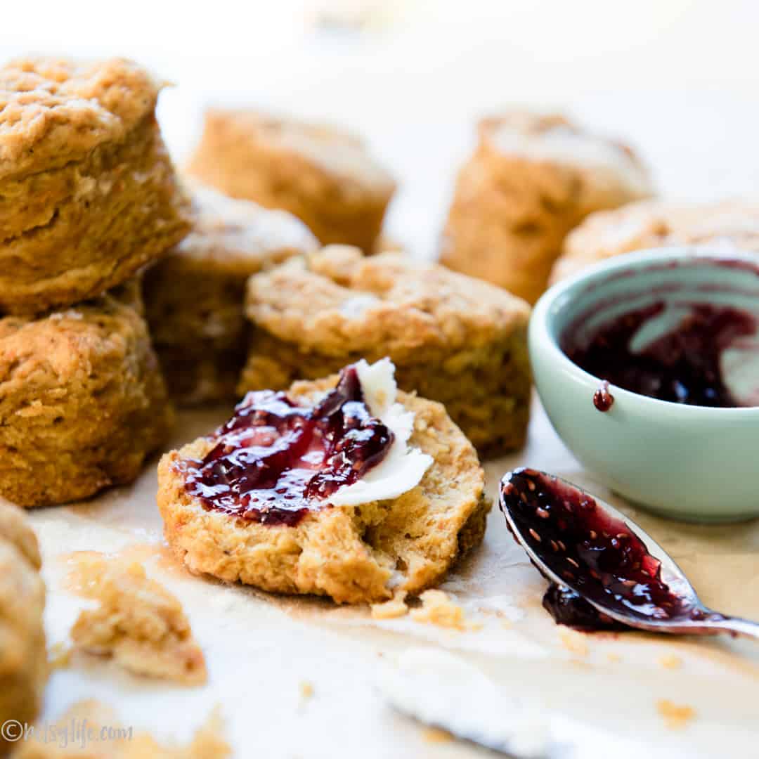 flaky sweet potato biscuit spread with butter and strawberry jam 