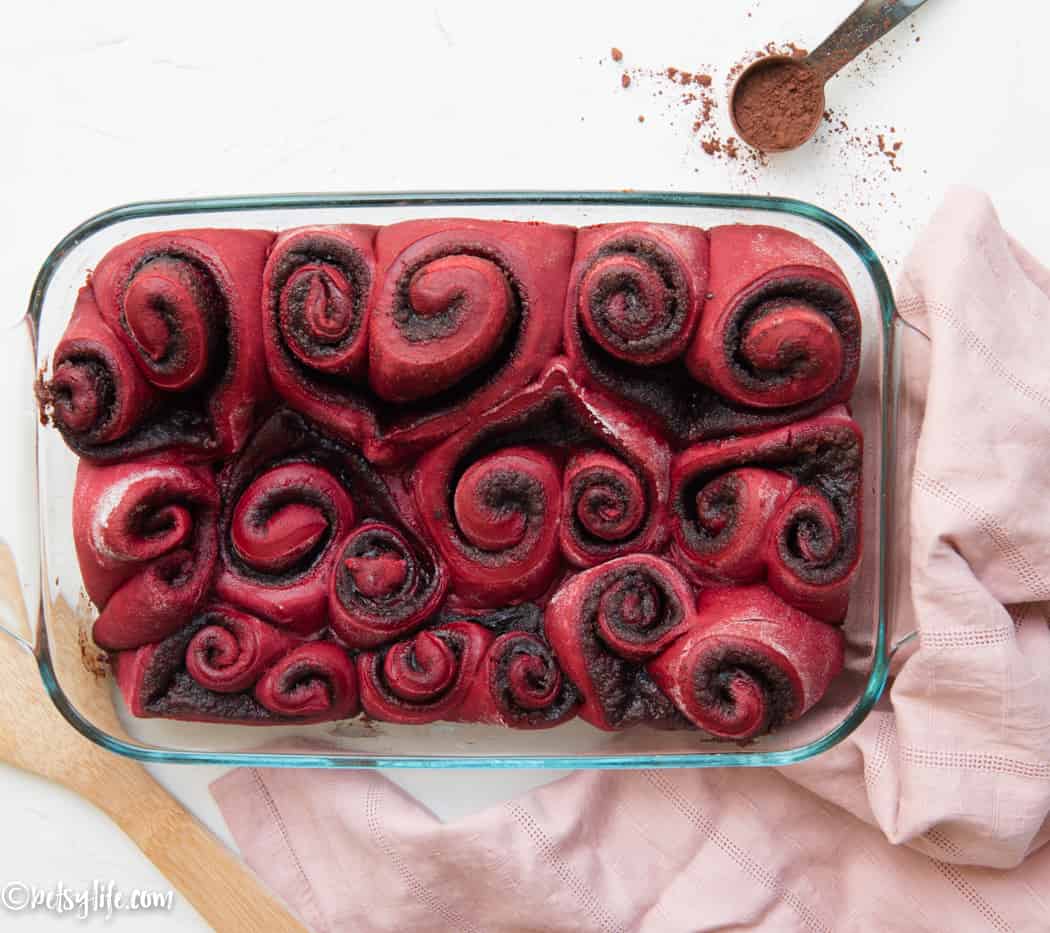 Rectangular baking dish filled with heart shaped red velvet cake mix cinnamon rolls 